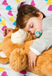 Sweet child sleeping with teddy bear