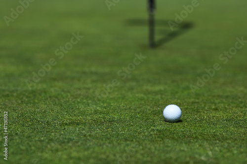 Photo: golf ball on lip of cup golf ball on lip of cup