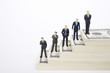 Businessman figurines standing on dollars stairway