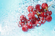 water splashing on a bunch of red grapes-top view