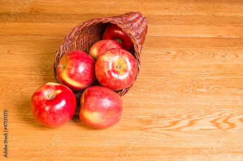 Photo: Red apples on table in cornucopia Red apples on table in cornucopia
