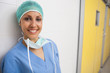 Smiling nurse leans against wall