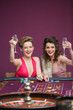 Women raising champagne glasses at roulette table