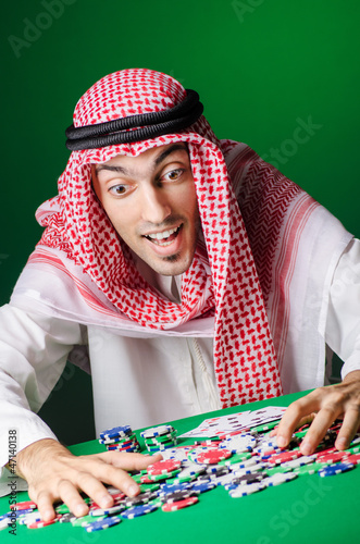 Photo: Arab playing in casino - gambling concept with man Arab playing in casino - gambling concept with man