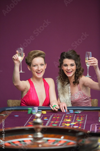 Photo: Women raising champagne glasses at roulette table Women raising champagne glasses at roulette table