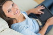 Woman sitting on the sofa and using a digital tablet