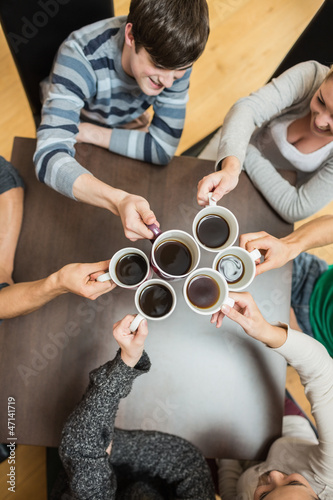 Photo: People holding up cups of coffee People holding up cups of coffee