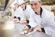 Smiling Chef's finishing dessert plates