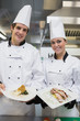 Two happy Chef's showing plates
