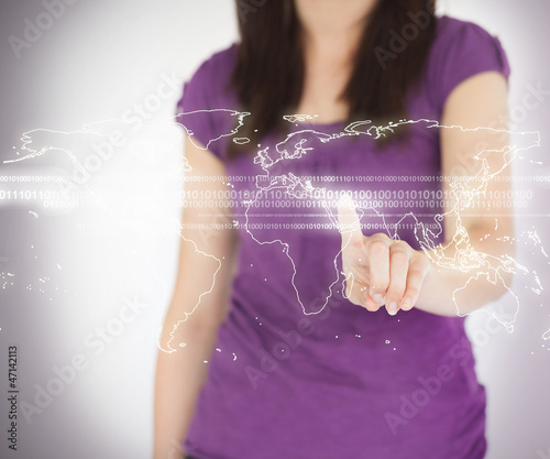 Photo: Woman standing using world map projection Woman standing using world map projection