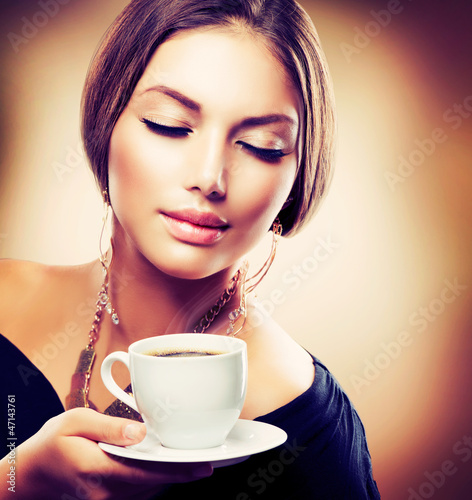 Photo: Beautiful Girl Drinking Tea or Coffee. Sepia Toned Beautiful Girl Drinking Tea or Coffee. Sepia Toned