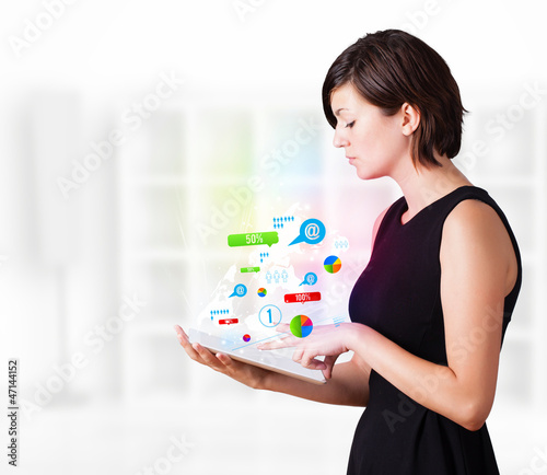 Photo: Young woman looking at modern tablet with colourful technology i Young woman looking at modern tablet with colourful technology i