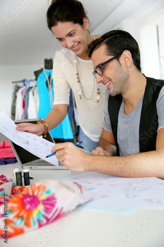 Photo: Fashion designers working on creation in workshop Fashion designers working on creation in workshop