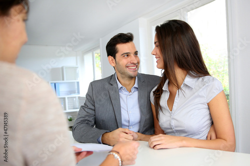 Photo: Young couple signing financial contract Young couple signing financial contract