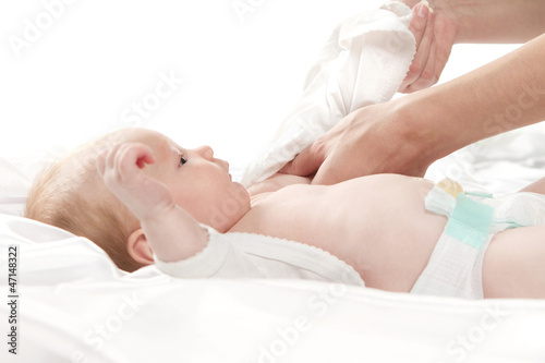 Photo: Close up of mother taking care of baby girl isolated on white Close up of mother taking care of baby girl isolated on white