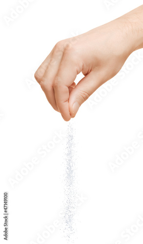 Photo: Hand adding salt on a white background Hand adding salt on a white background