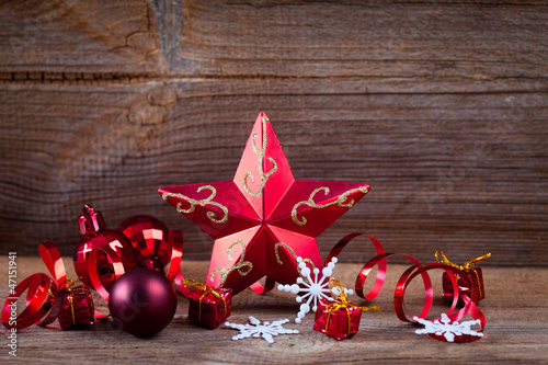 Photo: red star , gifts and ribbons on weathered wooden board red star , gifts and ribbons on weathered wooden board