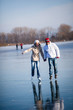 Couple ice skating outdoors on a pond on a lovely sunny winter d