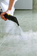 Woman cleaning  drain in bathroom with steam