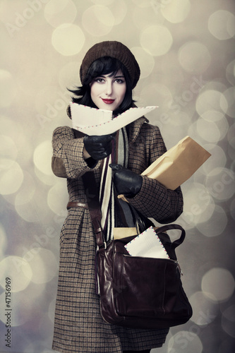 Photo: Young postman girl with mail. Photo in old color style with boke Young postman girl with mail. Photo in old color style with boke