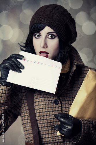Photo: Young postman girl with mail. Photo in old color style with boke Young postman girl with mail. Photo in old color style with boke