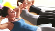 Three women doing sit ups together on exercise balls