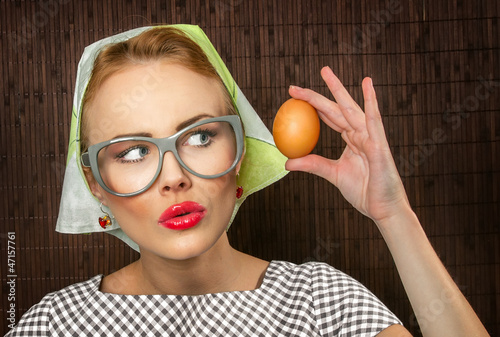 Photo: Funny woman cook holding egg,close-up Funny woman cook holding egg,close-up