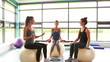 Women sitting on exercise balls lifting weights