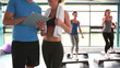 Women doing aerobics while trainer talking with woman