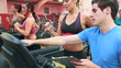 Trainer talking to woman on treadmill