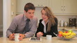 Couple sitting in the kitchen with tablet pc