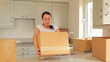 Woman bringing moving boxes into kitchen