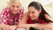 Video: Women lying looking through magazine Women lying looking through magazine
