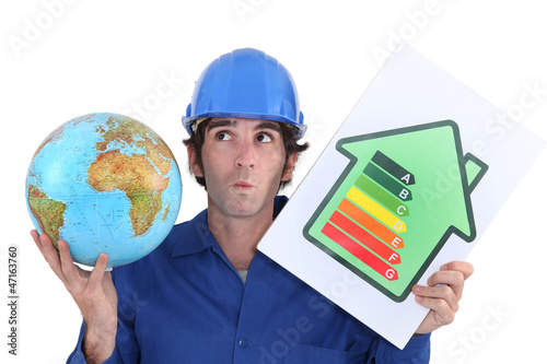 Photo: craftsman holding an energy consumption label and a globe craftsman holding an energy consumption label and a globe