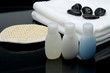 Spa setting, shampoo, towel, stones and bath glove