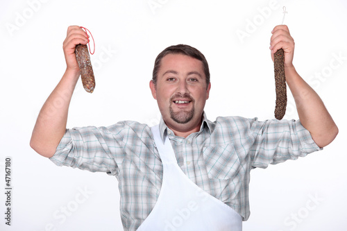 Photo: butcher holding fresh sausages butcher holding fresh sausages