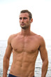Shirtless muscular male model with sea behind