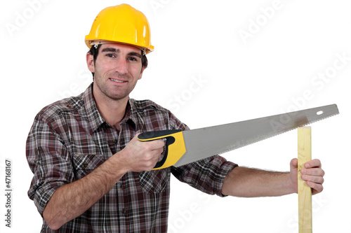 Photo: Man sawing plank of wood Man sawing plank of wood