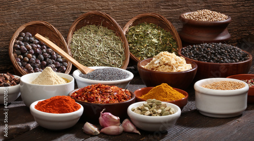 Photo: Various bowls of spices over wooden background. Various bowls of spices over wooden background.