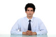 Man in a suit and tie sitting at a desk
