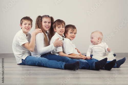 Photo: Group of kids in jeans sitting on floor Group of kids in jeans sitting on floor