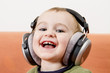 young child on couch with headphone