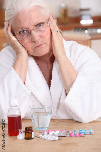 Photo: Grumpy woman taking her medication Grumpy woman taking her medication