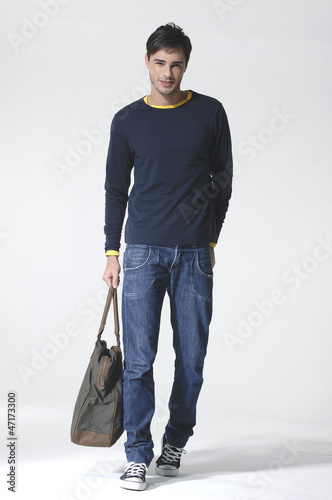 Photo: Full length young Casual man with bag posing in the studio Full length young Casual man with bag posing in the studio