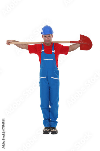 Photo: A construction worker with a shovel in a religious stance. A construction worker with a shovel in a religious stance.