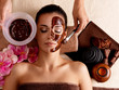 Spa therapy for woman receiving cosmetic mask