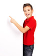 Portrait of  cheerful boy pointing on white banner