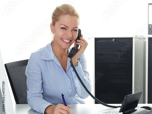 Photo: Young woman is having a good call in business Young woman is having a good call in business