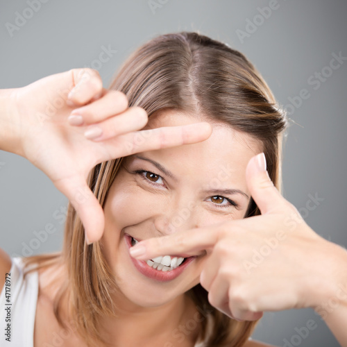 Photo: lachende frau schaut durch finger lachende frau schaut durch finger
