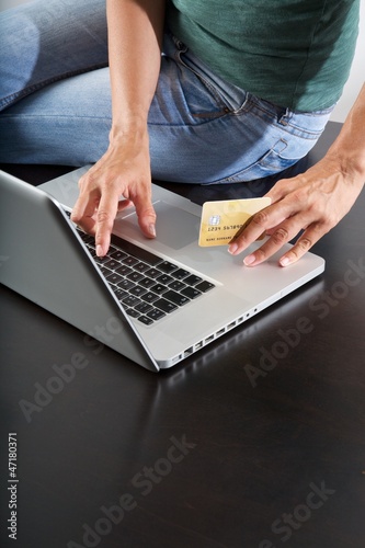 Photo: typing in laptop with credit card typing in laptop with credit card